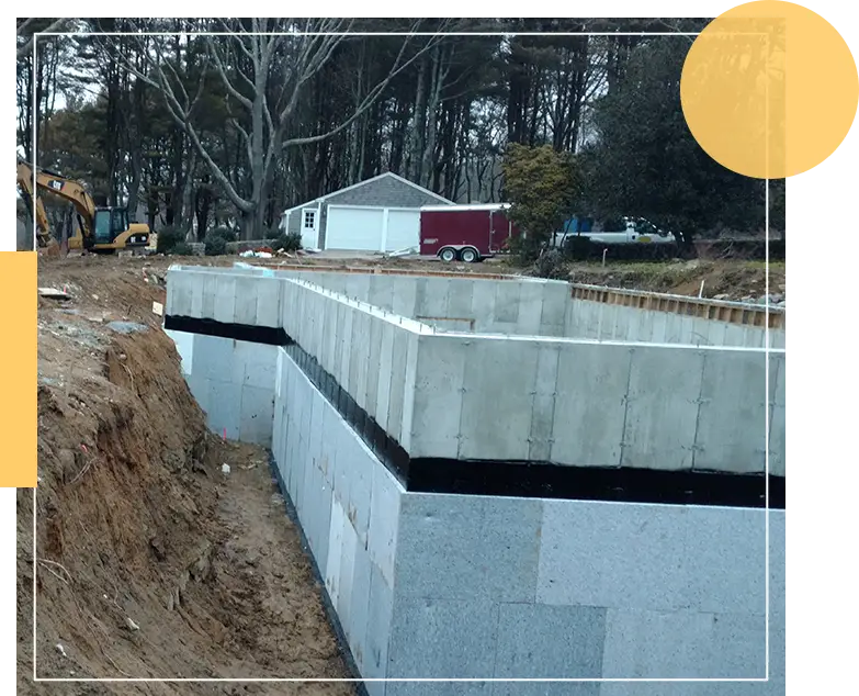 The image shows a construction site with a concrete foundation in progress, excavation equipment, and a small white building in the background.