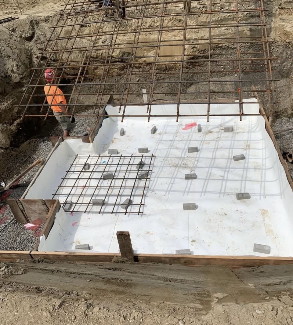 Construction site with steel reinforcement on a concrete slab.